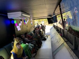 A group of people sitting on top of a bus.