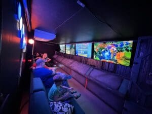 A group of people sitting in front of large screens.