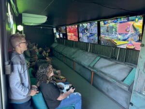 A group of people sitting in front of large screens.